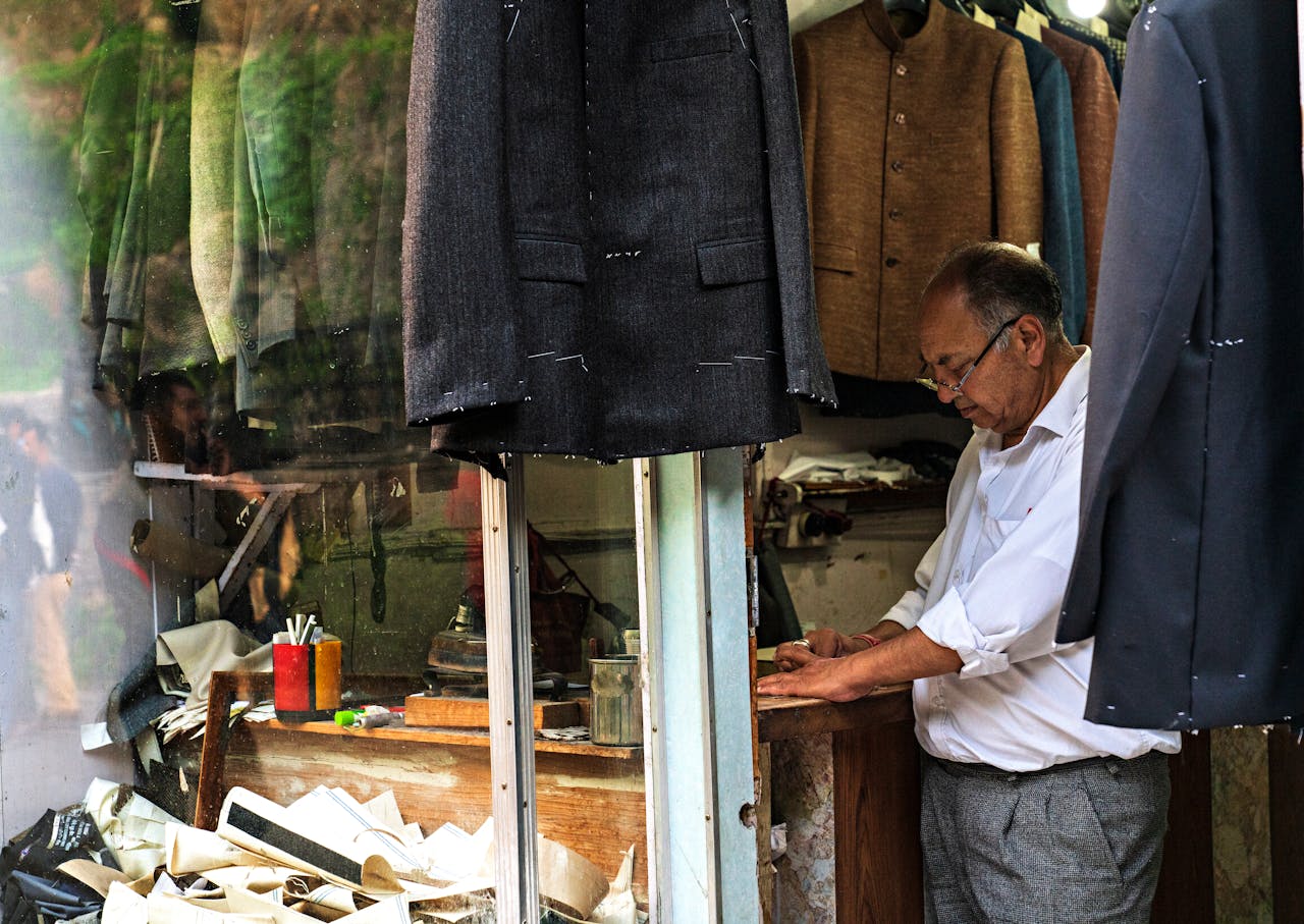 Mastering the First Impression: Your intriguing post title goes here An experienced tailor working in a classic sewing shop surrounded by suits and materials.