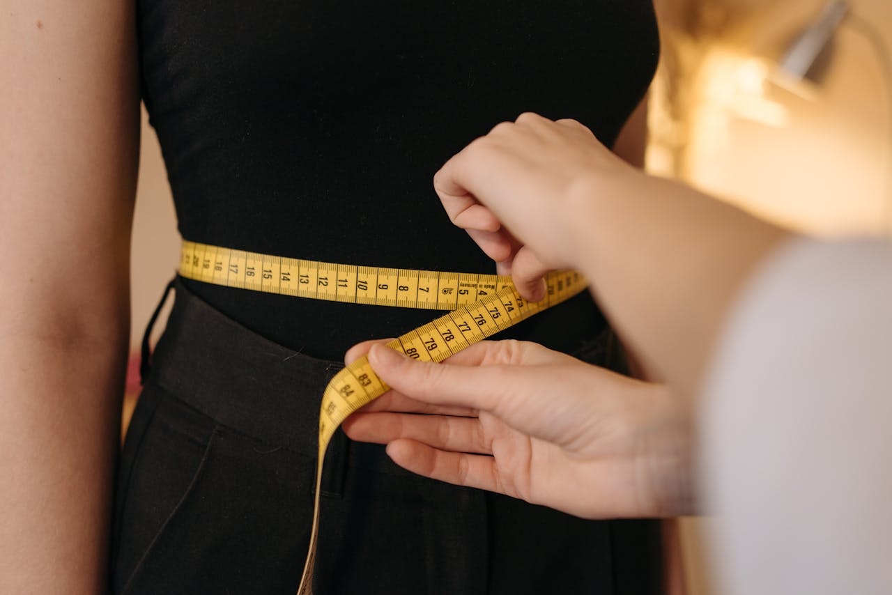 Crafting Captivating Headlines: Your awesome post title goes here Close-up of tailor's hands measuring a person's waist with a yellow tape.